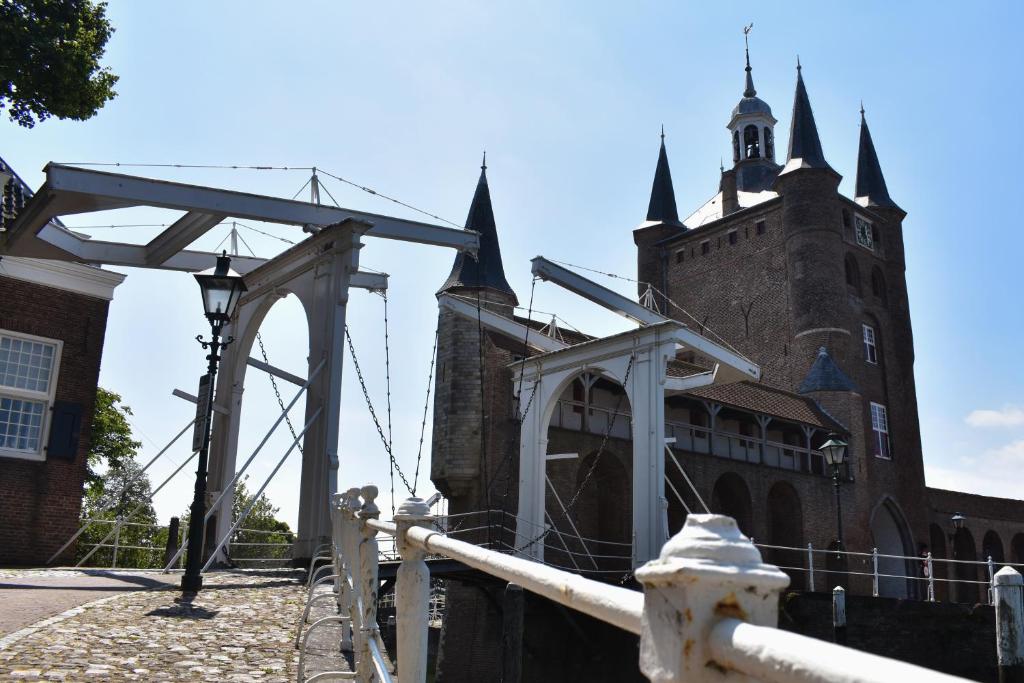 ein altes Gebäude mit einem Turm mit einer Uhr drauf in der Unterkunft Pension Het Pakhuys in Zierikzee