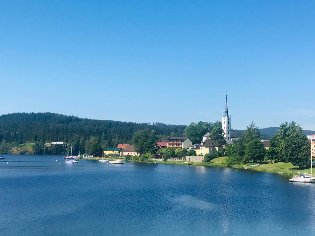 a large river with boats in the middle of a town at Mala Narnia in Frymburk