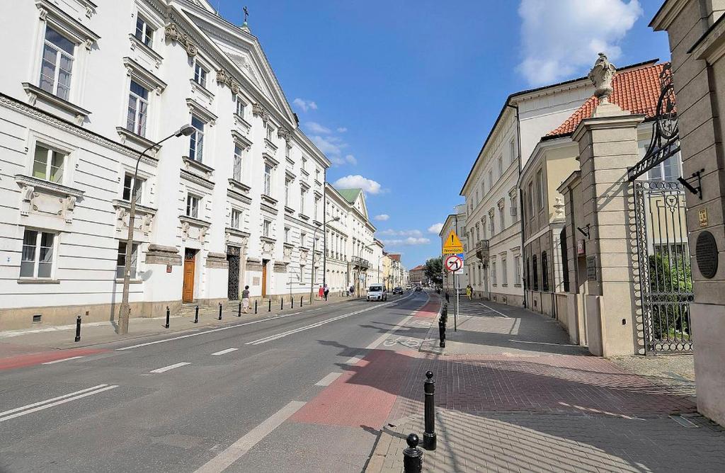 ワルシャワにあるOld Town PENTHOUSE P&O Serviced Apartmentsの晴れた日の白い建物が並ぶ空き街道