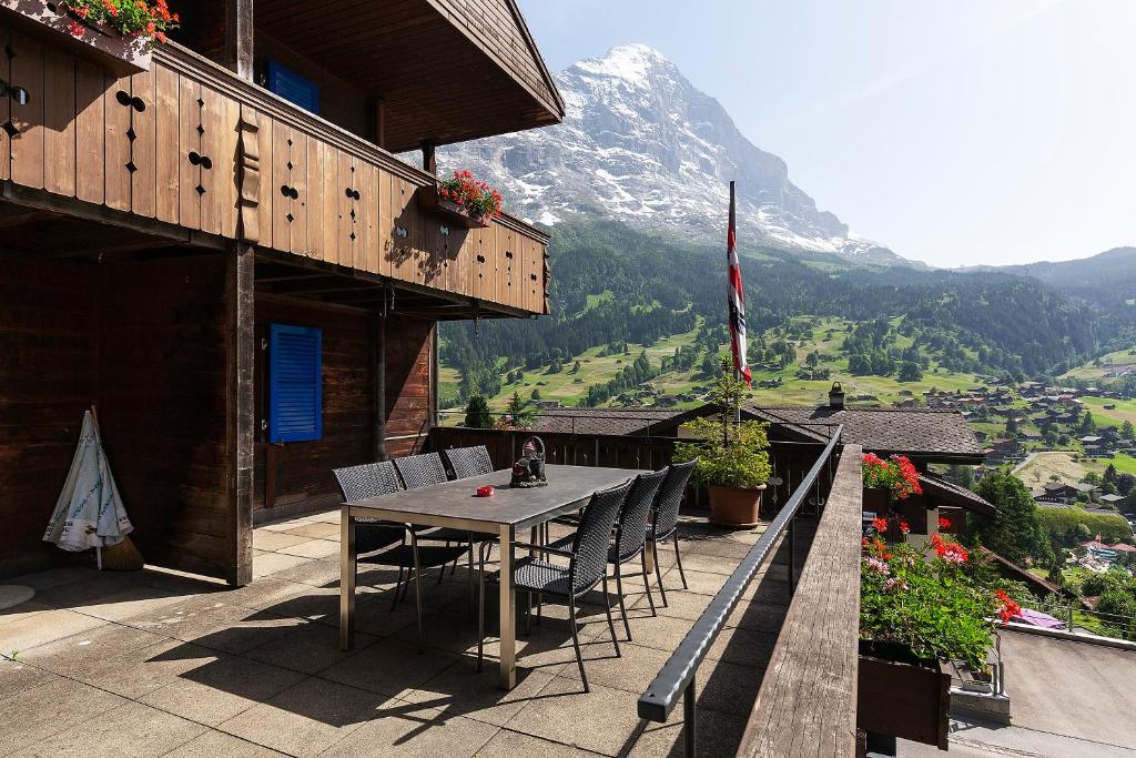 a table and chairs on a balcony with a mountain at Apartment Jungfrau Lodge in Grindelwald