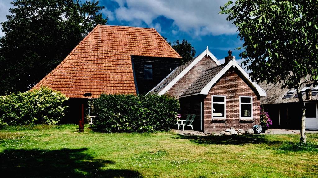 une petite maison en briques avec un toit rouge dans l'établissement Onder de Appelboom, à Garminge