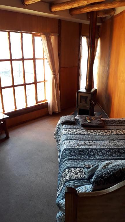 um quarto com uma cama e um fogão em La rosadita restotur em Palena