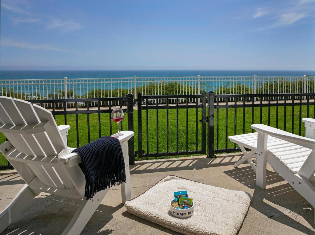 eine Terrasse mit 2 Schaukelstühlen und Meerblick in der Unterkunft Pismo Lighthouse Suites in Pismo Beach