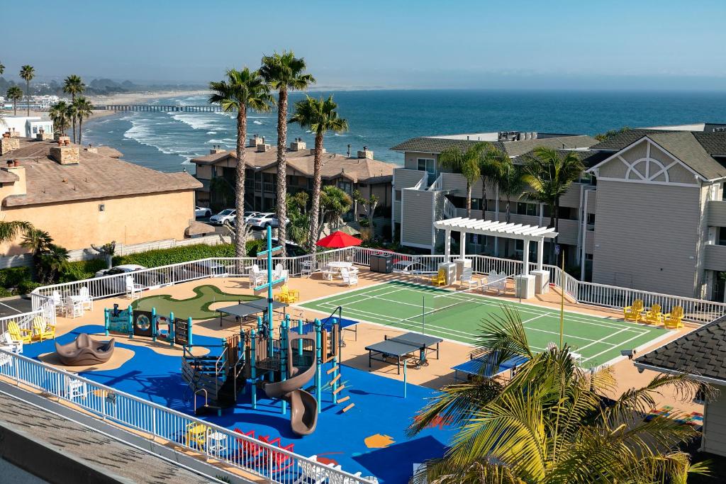 a beach with a pool and a tennis court at Pismo Lighthouse Suites in Pismo Beach