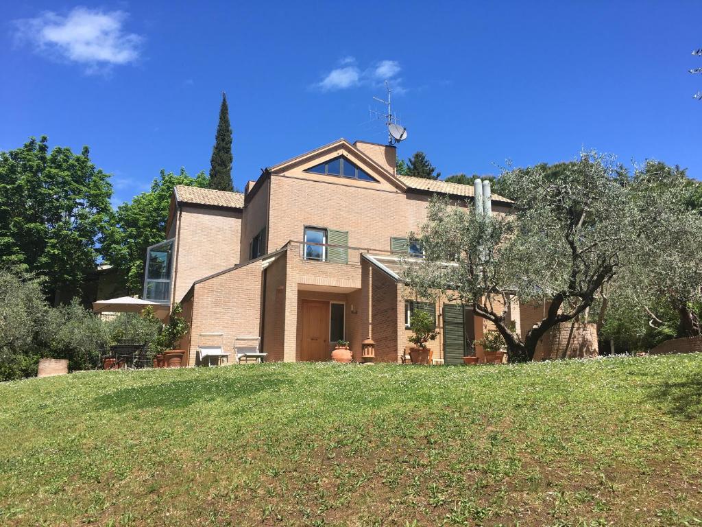 una grande casa in mattoni su una collina erbosa di B&B Villino Ada a Pesaro