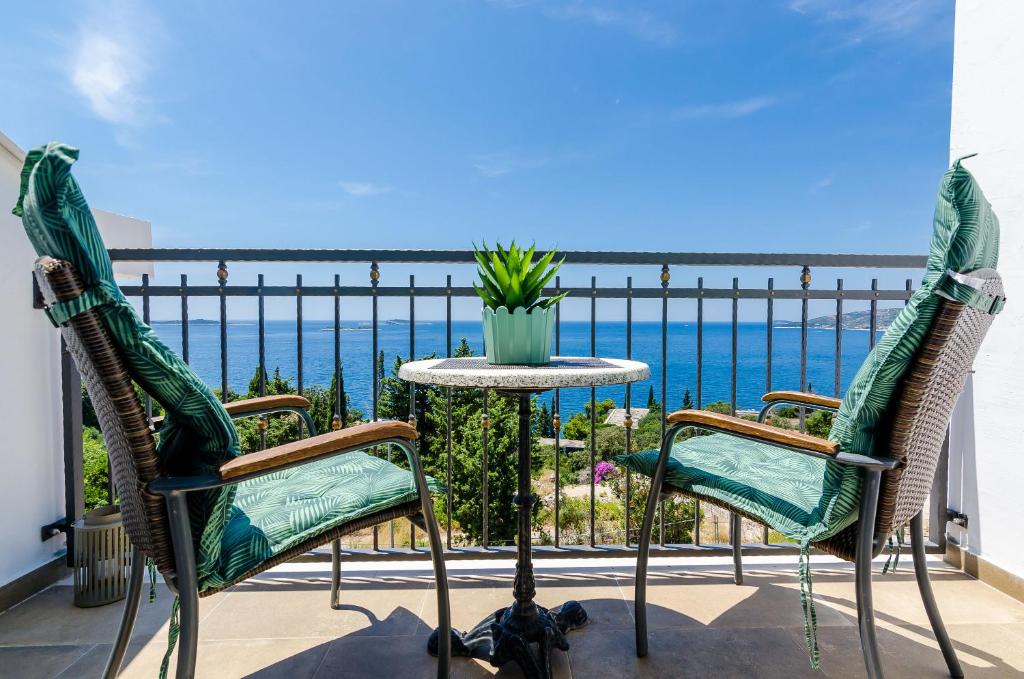 un patio con 2 sillas y una mesa con vistas al océano en King Suite, en Mlini