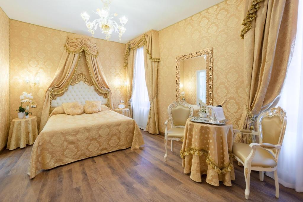 a bedroom with a bed and a table and a mirror at Canal View San Marco Luxury Rooms in Venice