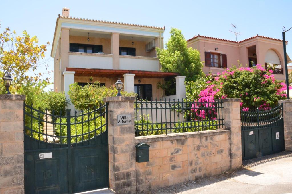 a house with a black gate and flowers at Villa Artemis in Aegina Town