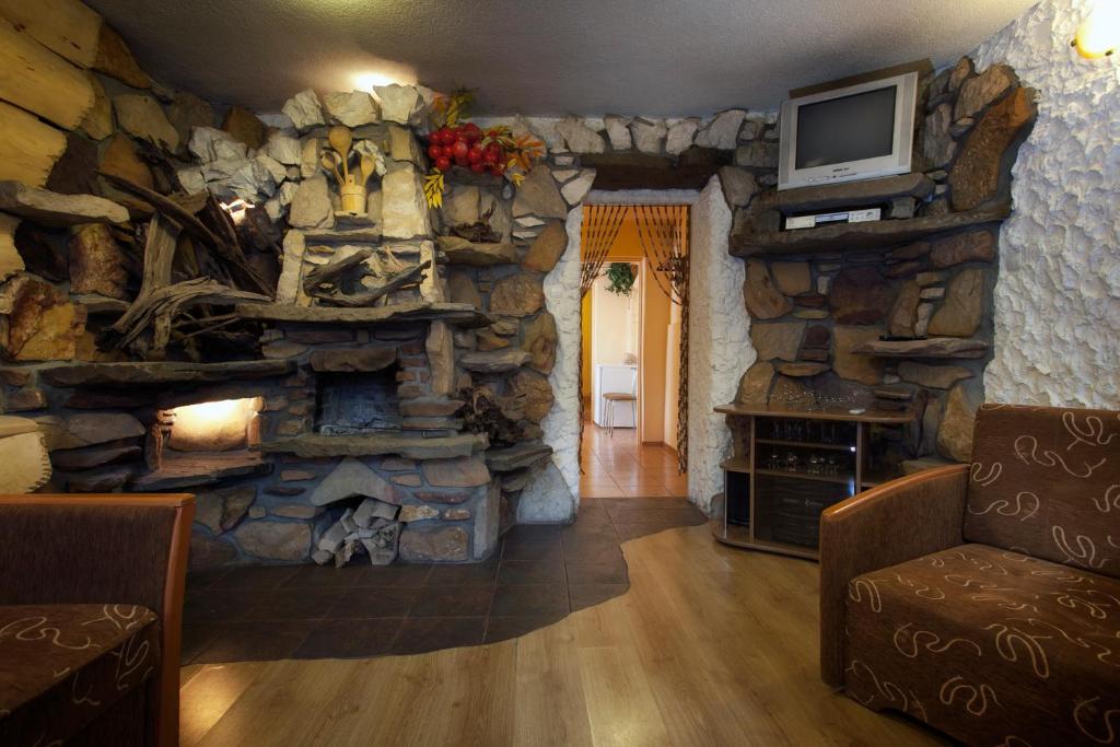 a living room with a stone wall with a fireplace at Pokoje Oko in Zakopane
