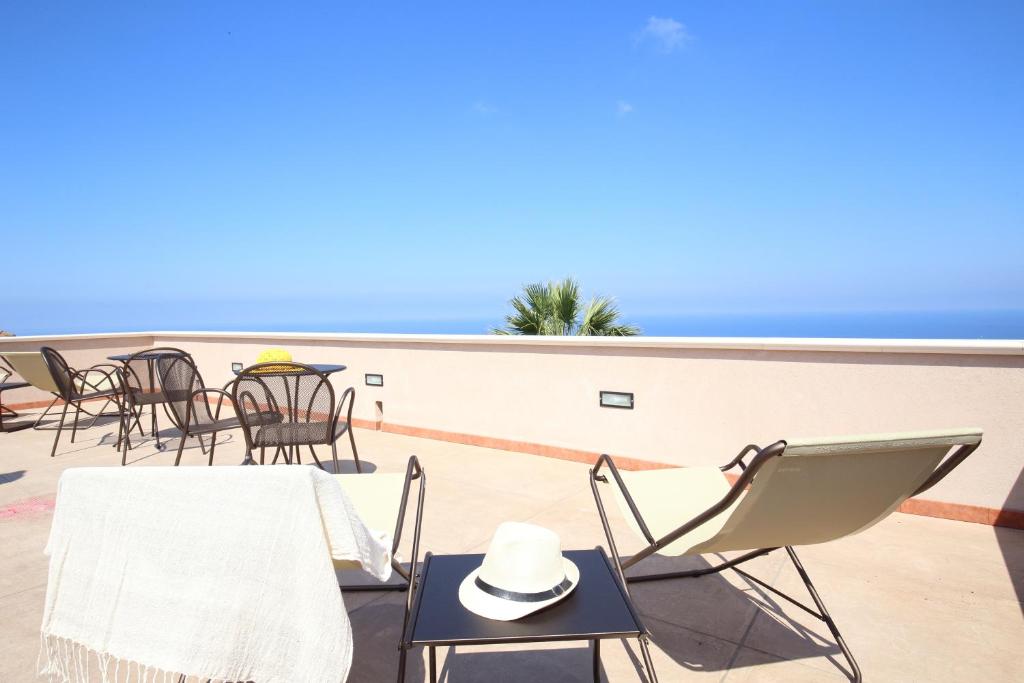 un tavolo e sedie su un balcone con vista sull'oceano di B&B villa orchidea a Ricadi