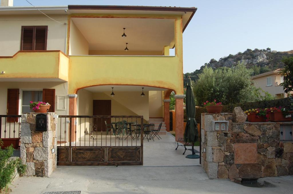 ein Haus mit einem Balkon und einer Terrasse in der Unterkunft B&B Il Corbezzolo in Posada