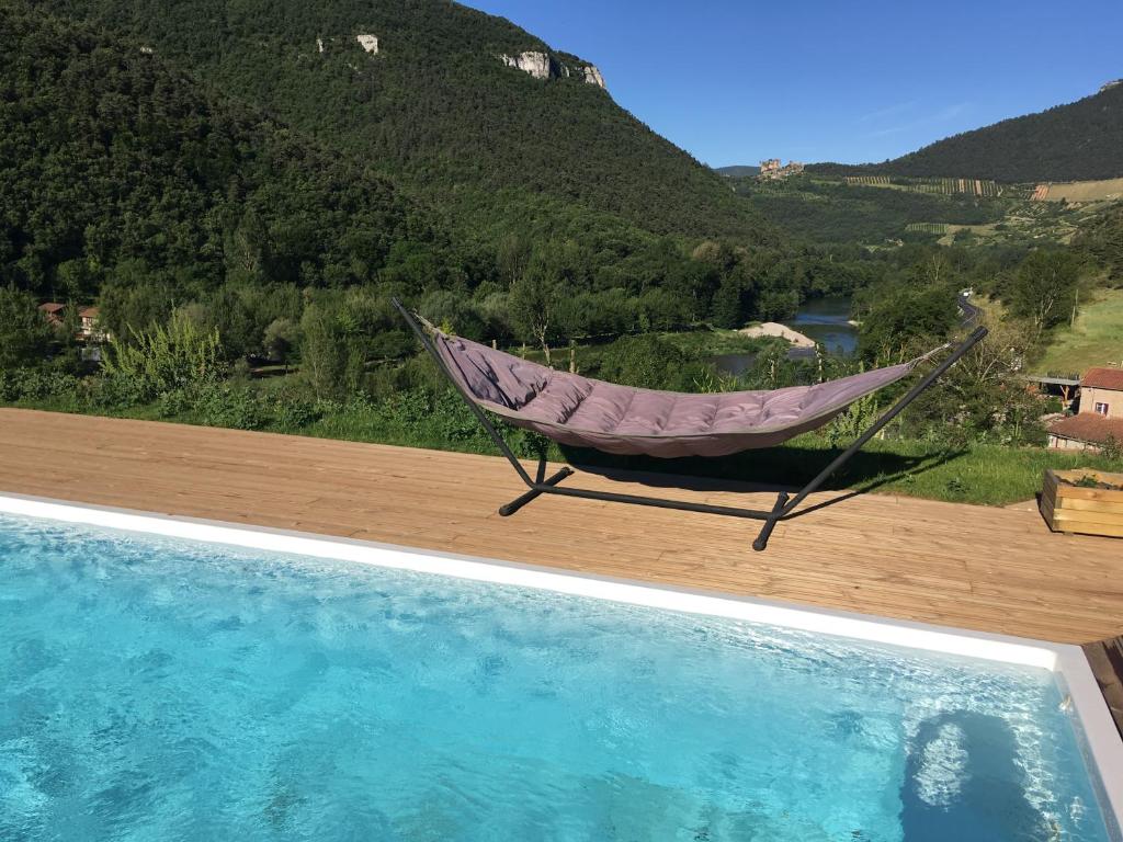 een hangmat naast een zwembad bij Villa le Tresquel in Mostuéjouls