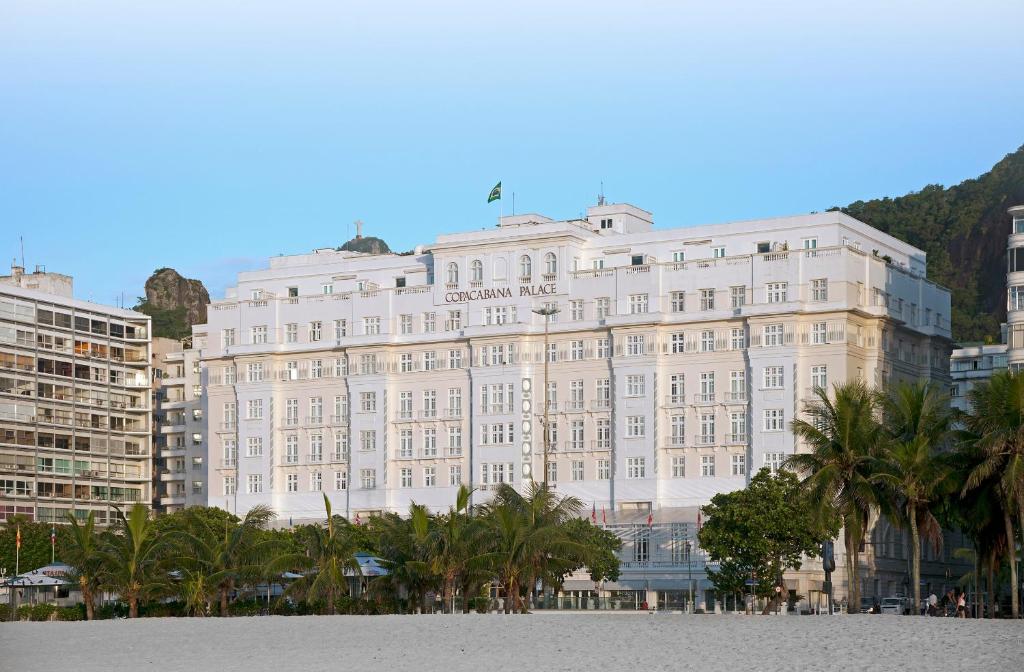 un gran edificio blanco con palmeras delante en Copacabana Palace, A Belmond Hotel, Rio de Janeiro, en Río de Janeiro