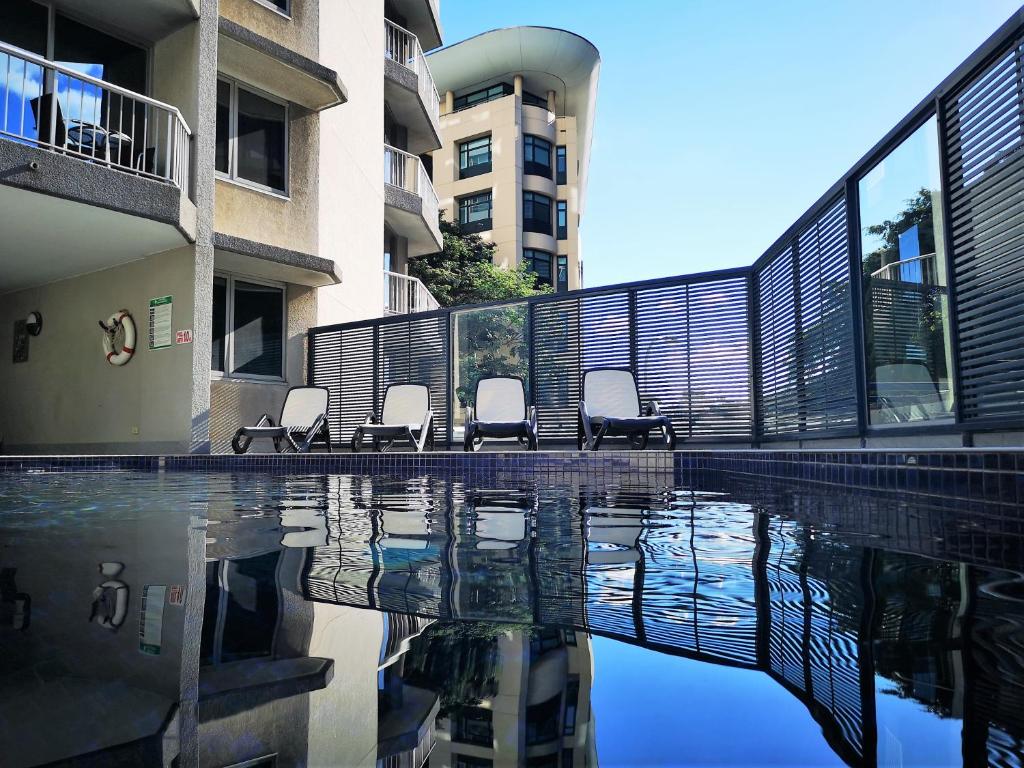 a swimming pool with chairs in a building at Abbey On Roma Hotel & Apartments in Brisbane