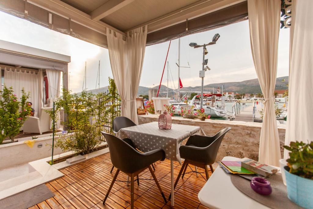 balcone con tavolo, sedie e vista su un porto turistico. di Studio Tironi a Trogir