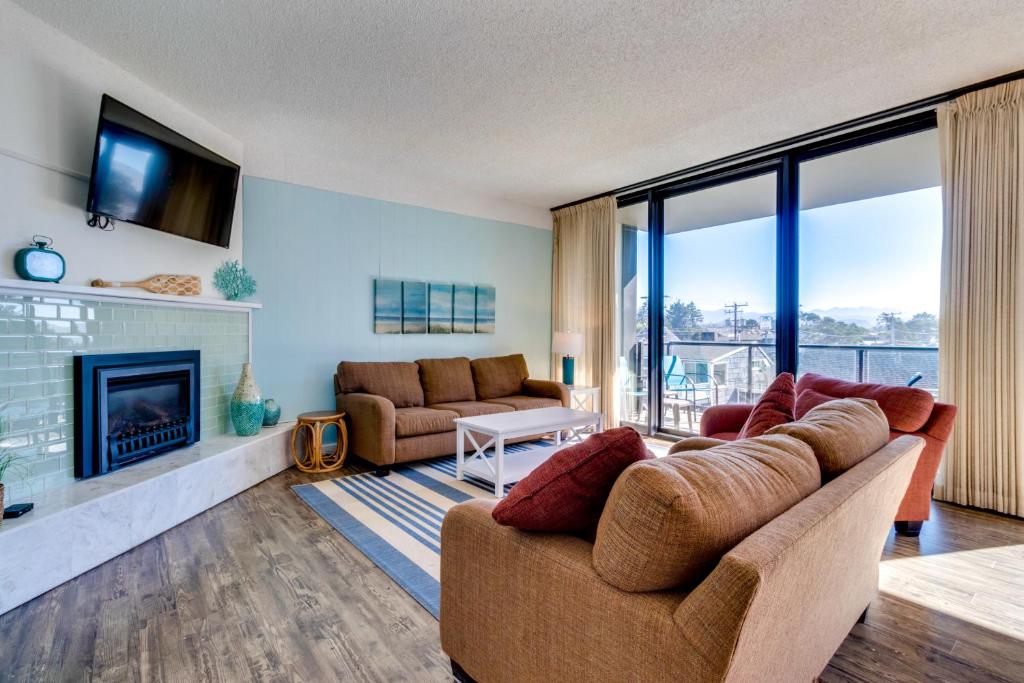a living room with a couch and a fireplace at Sand & Sea: Turtle Cove (214) in Seaside