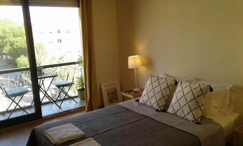 una camera con letto e finestra con balcone di apartamento a Porto
