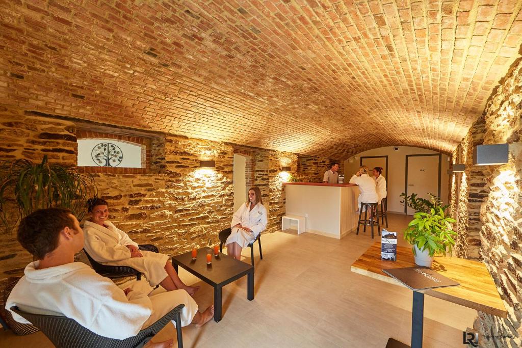 a group of people sitting in a room with a brick wall at Le Manoir de Kerbot in Sarzeau