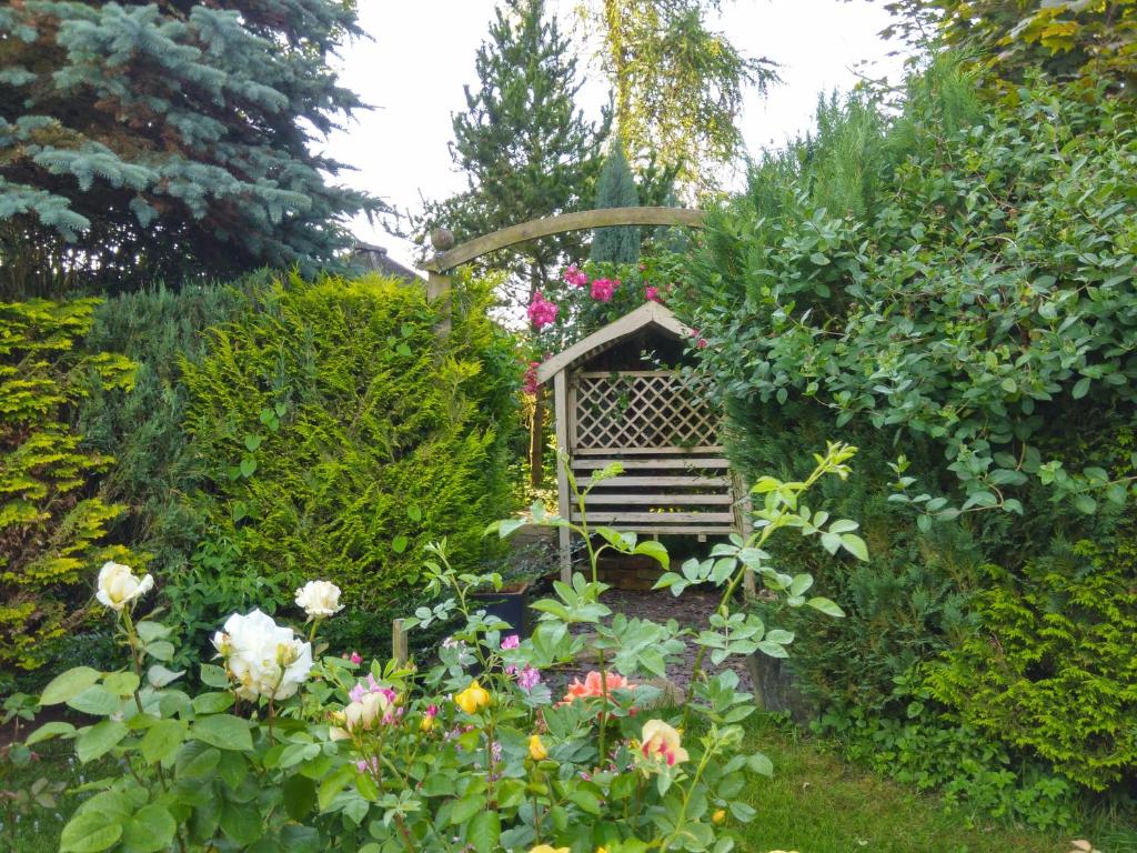 un jardín con un alimentador de aves y flores en Mountain Ash, en Horncastle