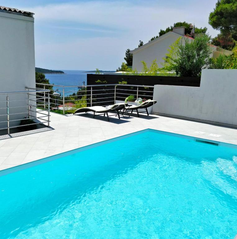 a blue swimming pool with a view of the ocean at Entire private top floor with own pool and entrance in Primošten