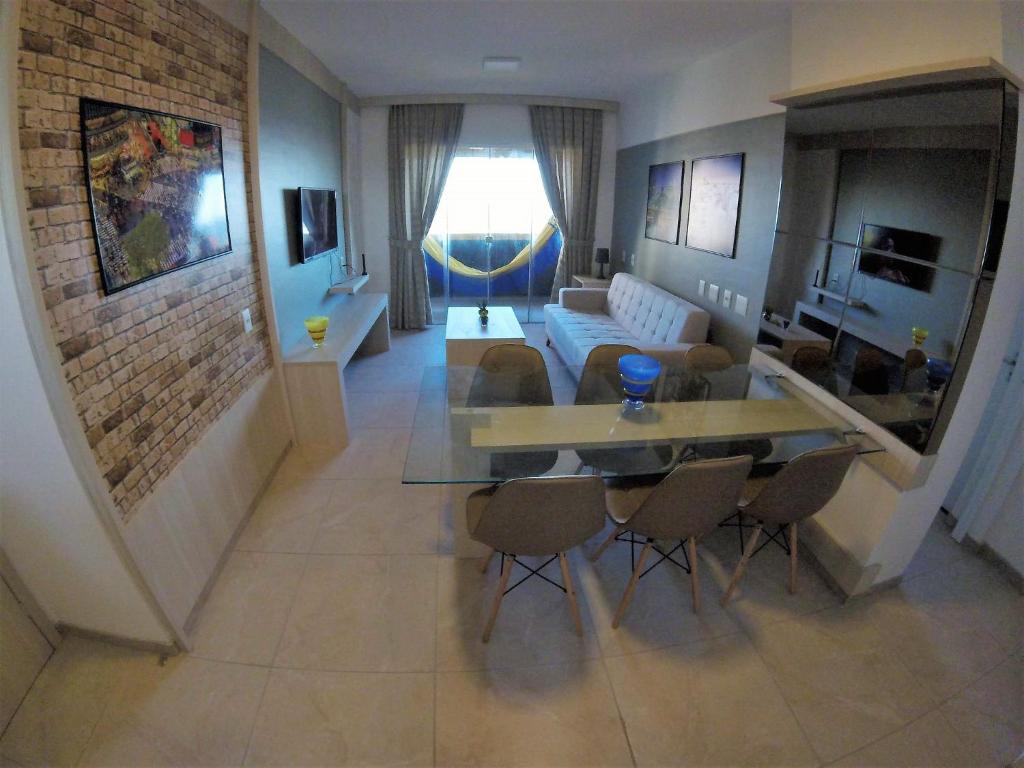 ein Wohnzimmer mit einem Sofa, einem Tisch und Stühlen in der Unterkunft Apartamento família e com linda vista mar in Fortaleza