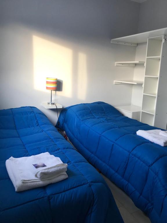 a blue couch sitting in a room with a lamp at Departamento en Chascomús a dos cuadras de laguna in Chascomús