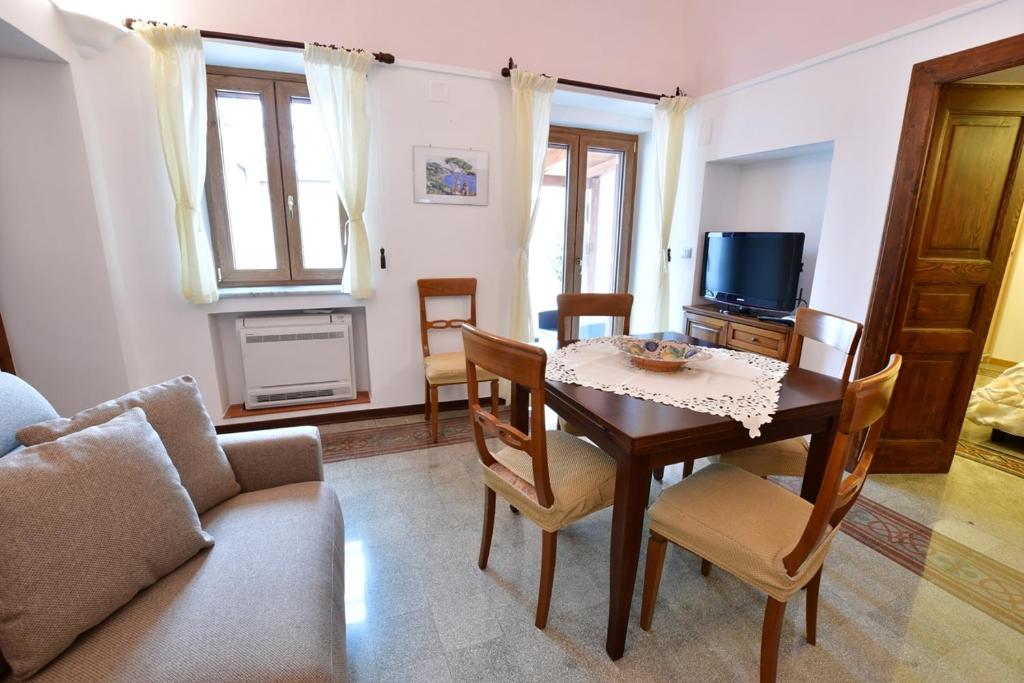 salon ze stołem i telewizorem w obiekcie Il Centro Storico Ravello w mieście Ravello