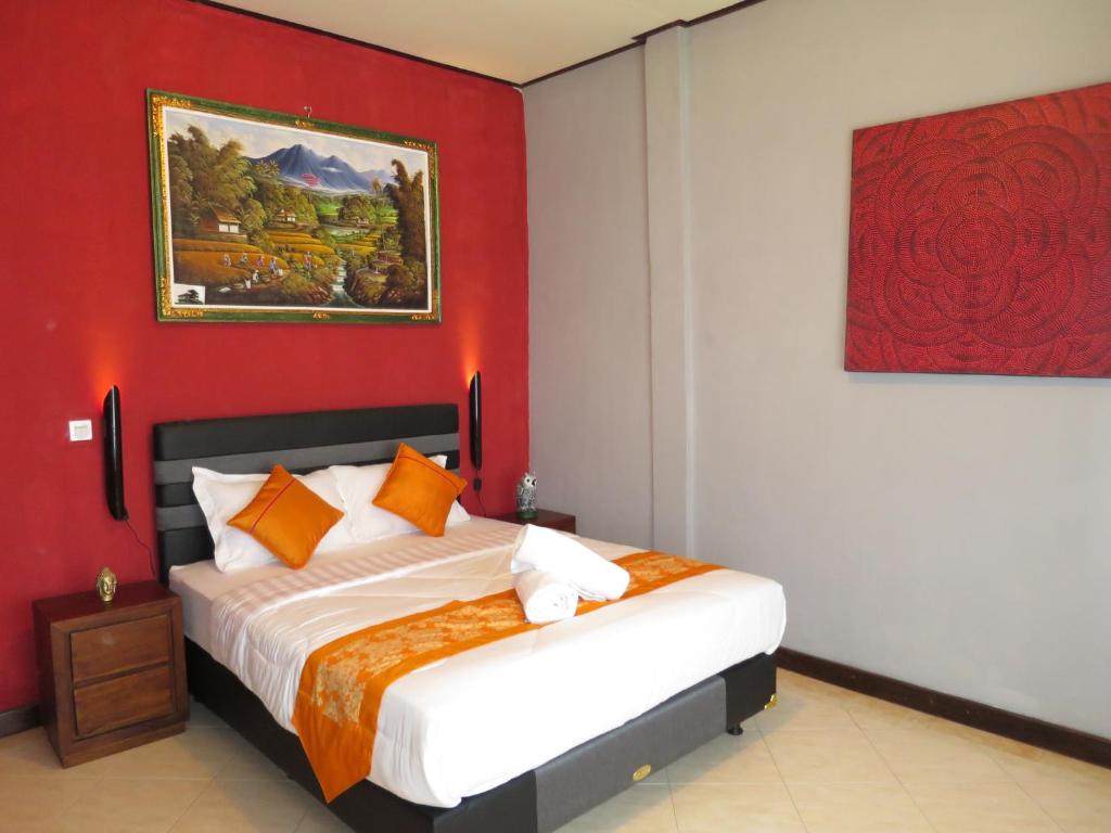a bedroom with a bed with a red wall at Mountain View House in Kintamani