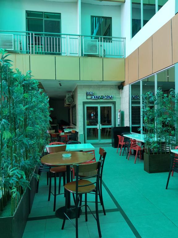 a patio with tables and chairs in a building at Lae City Hotel in Lae