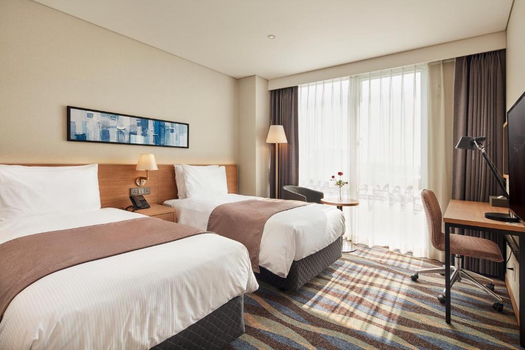 Postel nebo postele na pokoji v ubytování Ramada Encore by Wyndham Gimpo Han River Hotel