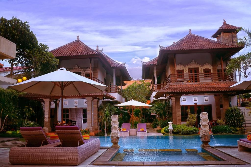 a resort with a swimming pool in front of a building at Puri Sading Hotel in Sanur