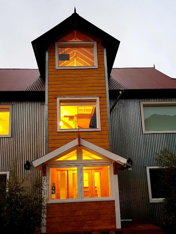 a house with two windows on the side of it at Aguila Mora Aparts in El Chalten