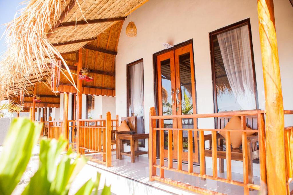a resort with a deck with chairs and tables at Dayuh House in Nusa Penida