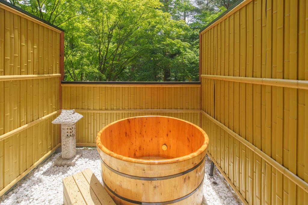 a wooden sauna with a wooden tub in the middle at Bself Fuji Onsen Villa in Fujiyoshida