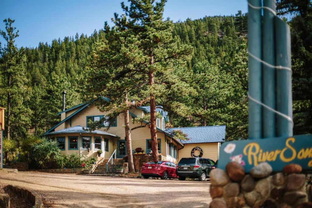 a house with cars parked in front of it at Romantic RiverSong Inn in Estes Park
