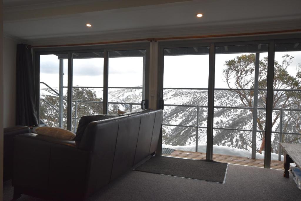a living room with a couch and a large window at Fountains 18 in Mount Hotham
