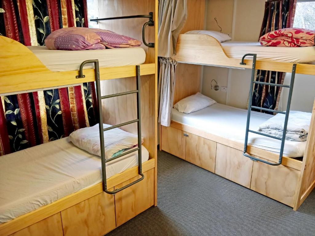 two bunk beds in a dorm room with at The Flaming Kiwi Backpackers in Queenstown