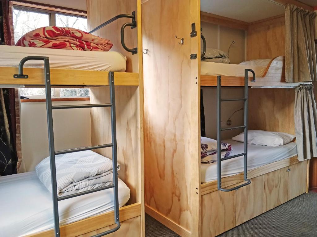 a couple of bunk beds in a tiny house at The Flaming Kiwi Backpackers in Queenstown