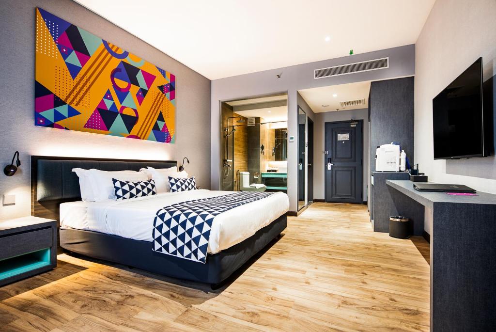 a bedroom with a king sized bed and a flat screen tv at TROVE Johor Bahru in Johor Bahru
