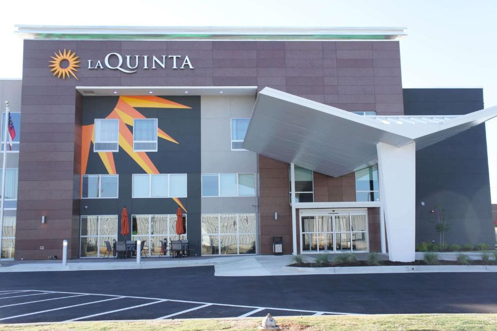 a building with a sign on the side of it at La Quinta by Wyndham Perry in Perry