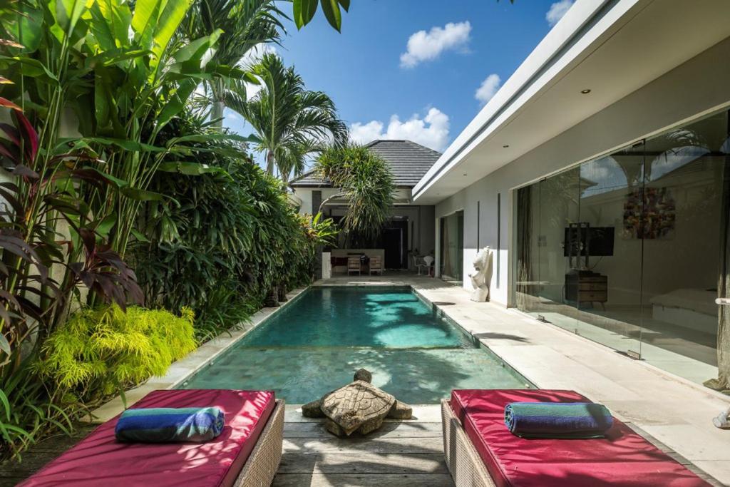 a swimming pool in the backyard of a house at Villa Kallayaan by Optimum Bali Villas in Seminyak