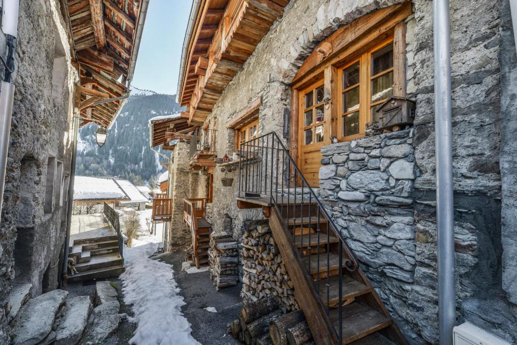 a stairway leading up to a building with snow on the ground at CHALET ALOUETTE Authentique et confortable Proche commerces et Pistes in Champagny-en-Vanoise