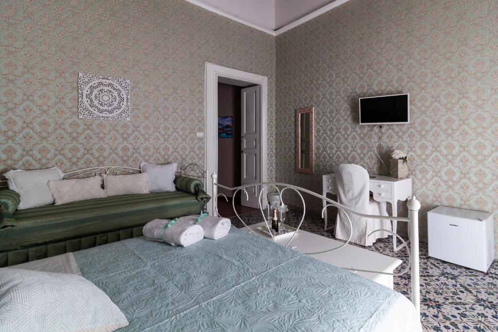 a bedroom with a green bed and a tv at Casa Maia in Naples