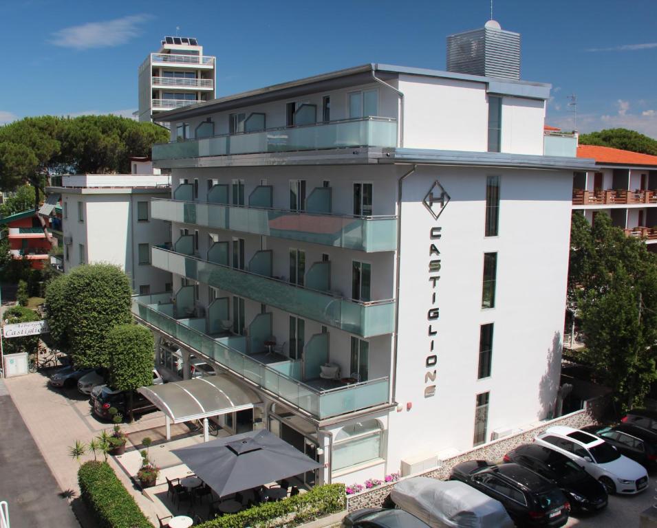 una vista aerea di un hotel con auto parcheggiate in un parcheggio di Hotel Castiglione a Lignano Sabbiadoro