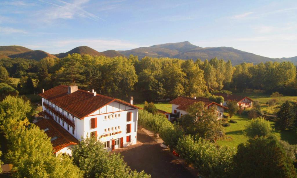 an aerial view of a house with mountains in the background at Hotel Pyrenées Atlantique in Saint-Pée-sur-Nivelle