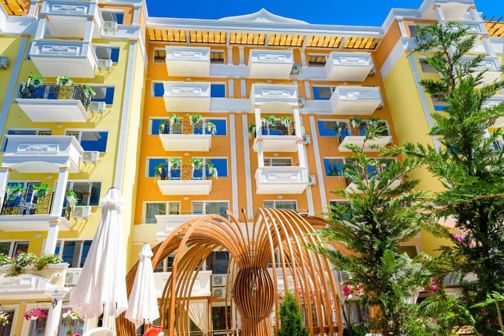 an apartment building with an arch and an umbrella at Sweet Homes Apartments in Sunny Beach