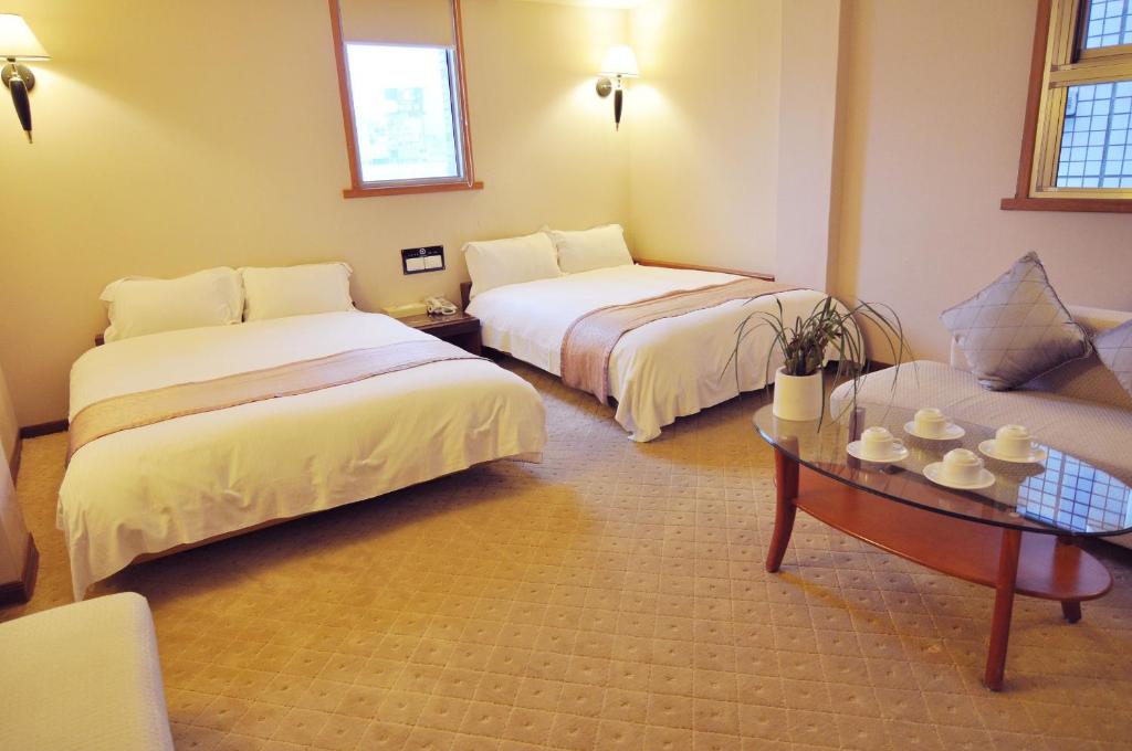 Postel nebo postele na pokoji v ubytování Tian Long Hotel