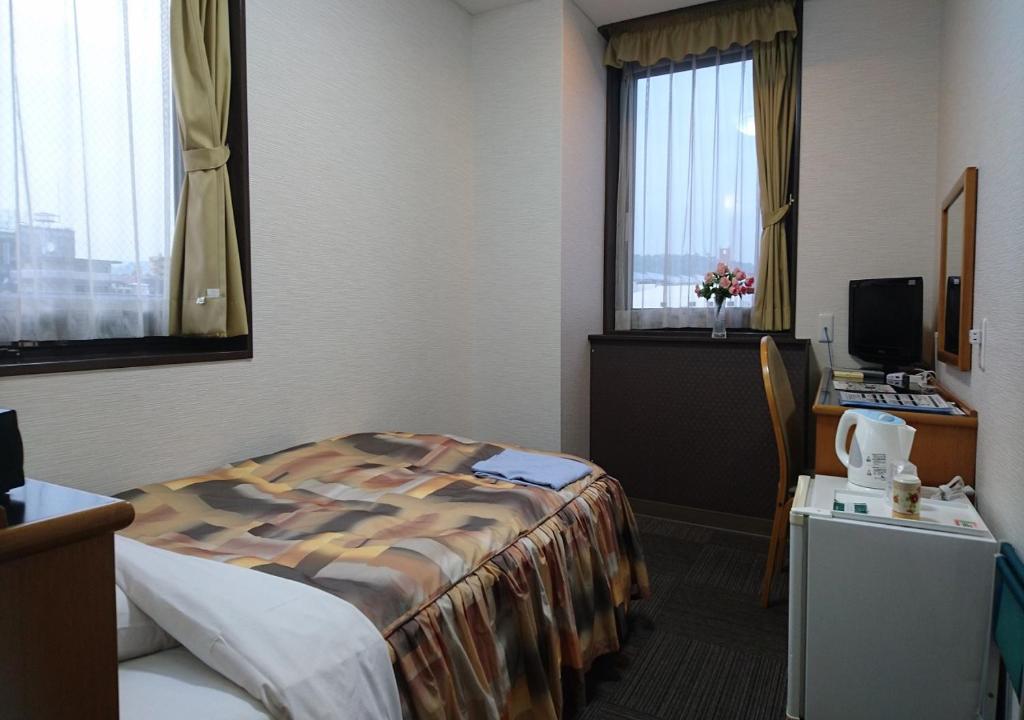 Postel nebo postele na pokoji v ubytování Terminal Hotel Matsuyama