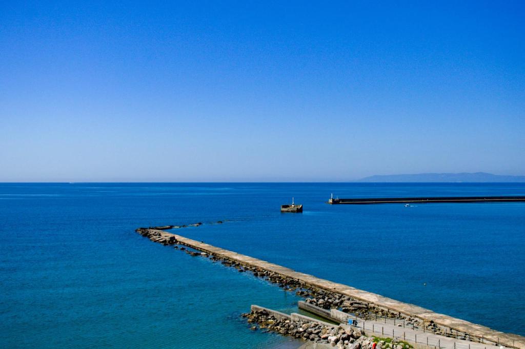 a dock in the ocean with a boat in the water at Hotel Plaza in Kalamata