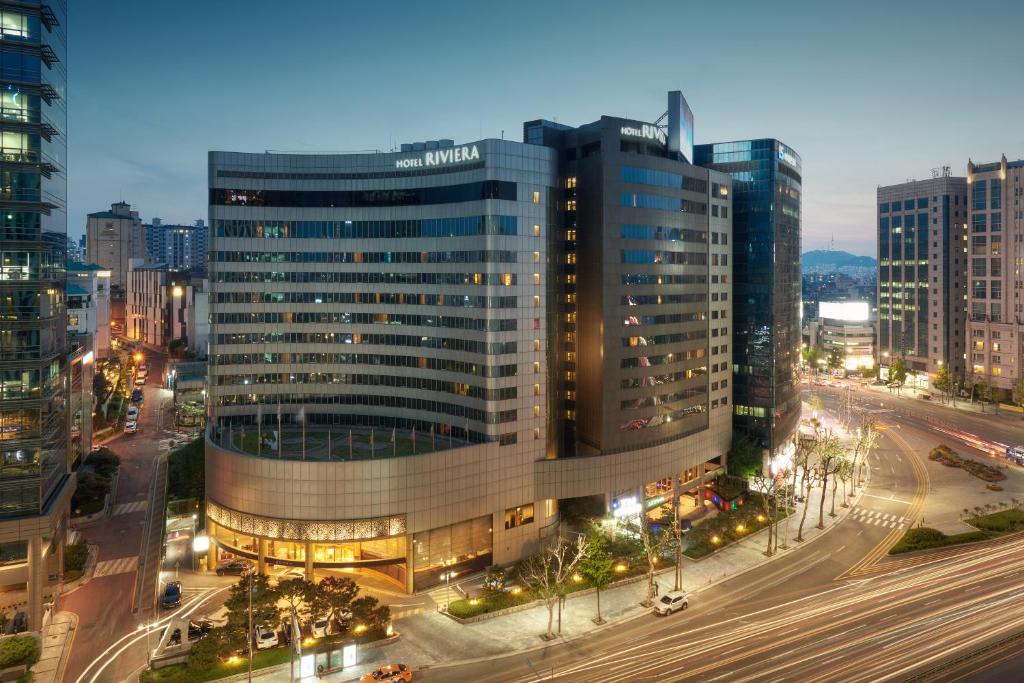 a large glass building in a city at night at Seoul Riviera Hotel in Seoul